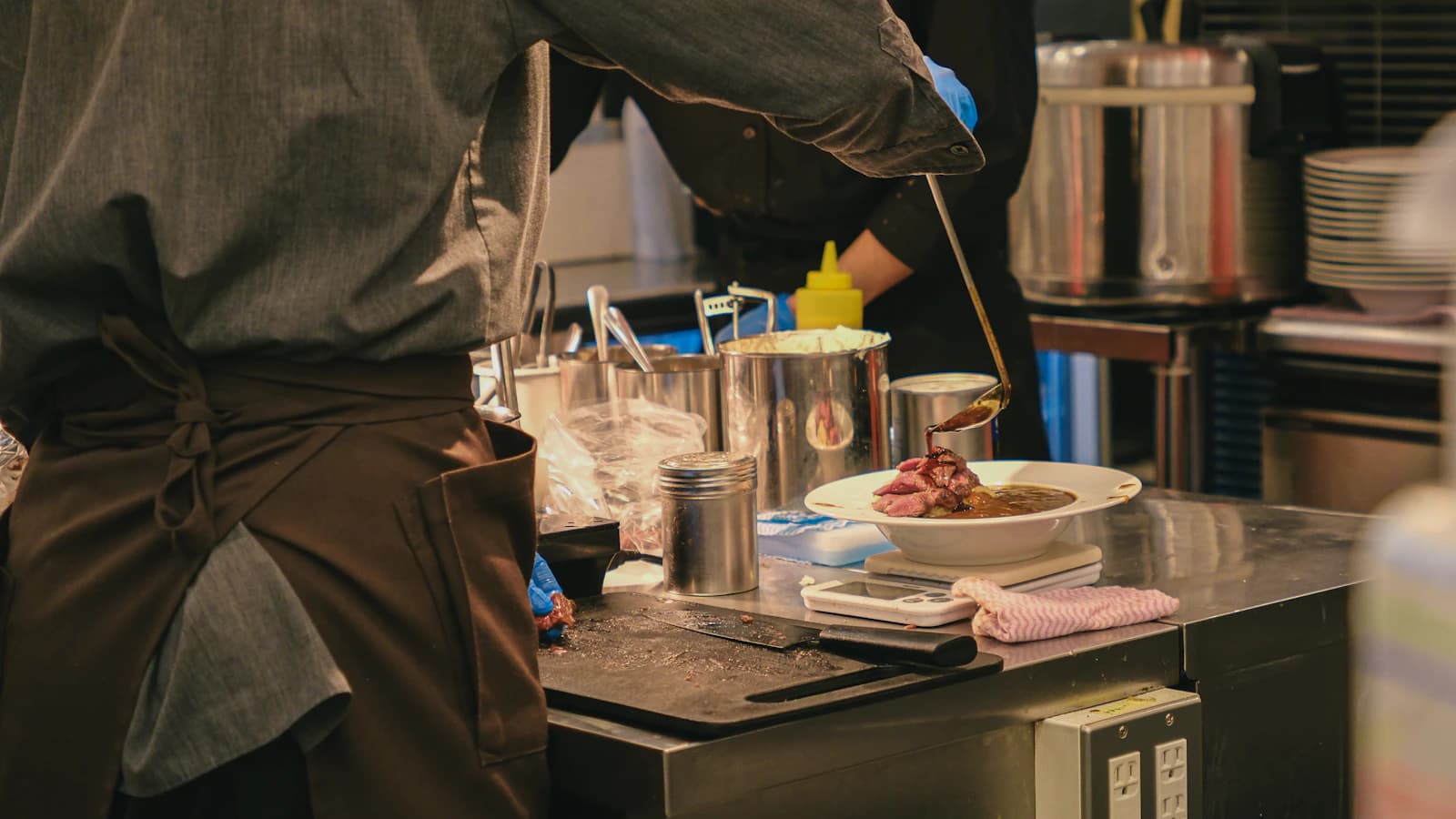 LSCAHM chef instructor coaching students during a working service